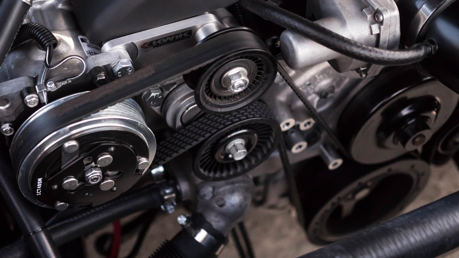 Close-up of a person inspecting the front wheel and tire of a parked used car