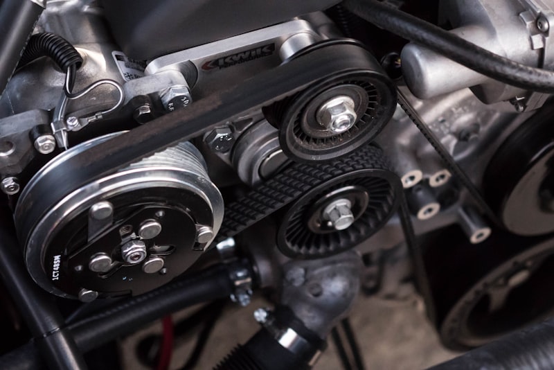 Close-up of a person inspecting the front wheel and tire of a parked used car