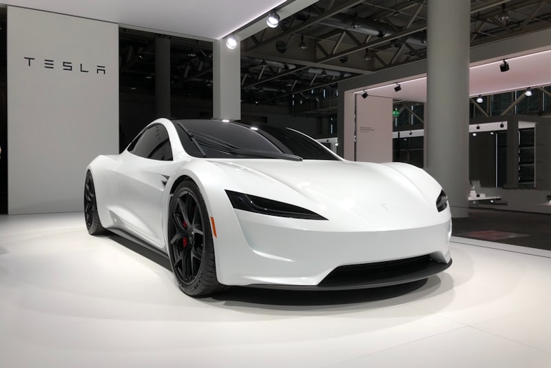 An electric car parked in a home driveway with the charge port door open